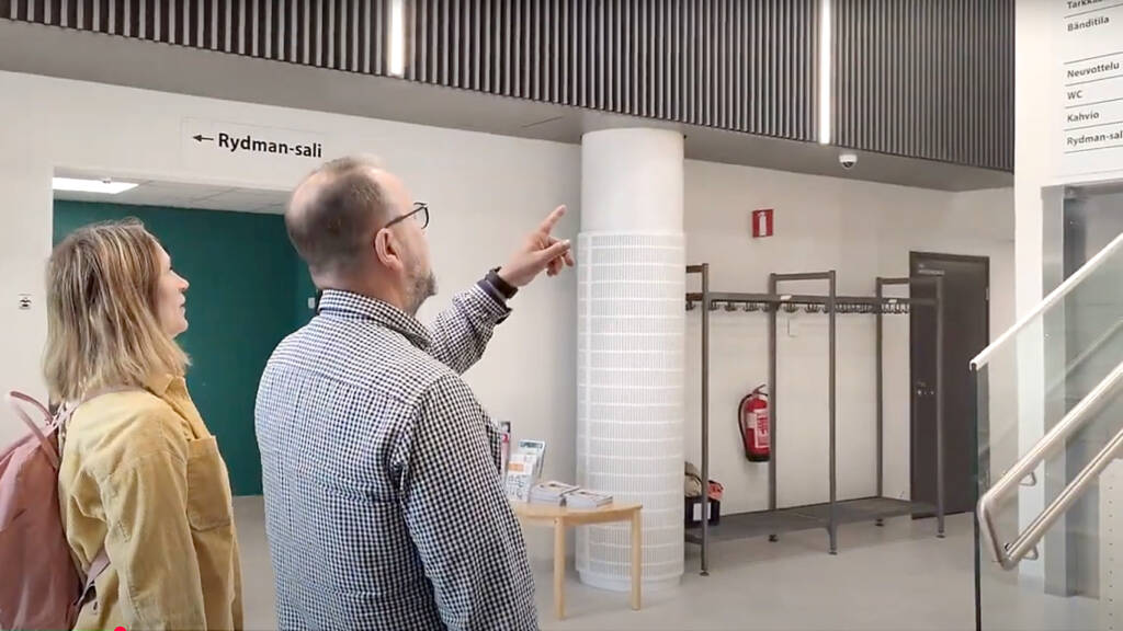 Kaksi henkilöä katsoo Kulttuurikeskus Luovan opastetaulua.