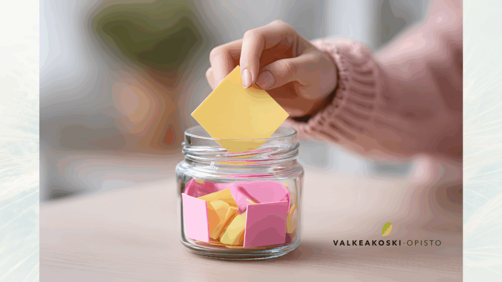 Käsi laittaa lasipurkkiin paperilapun.